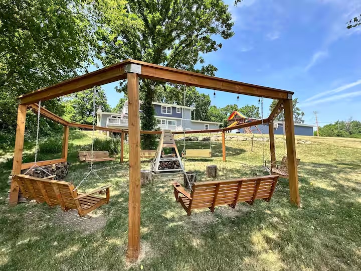 The octagon swings and firepit by day, with the rainbow playset beyond